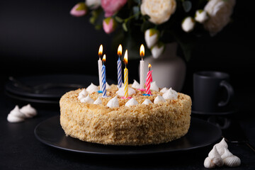 Plakat Whole holiday cake with crumbly shortcrust pastry and mini meringue. Birthday cake with lit candles.. Homemade baking. Black background, selective focus, close-up.
