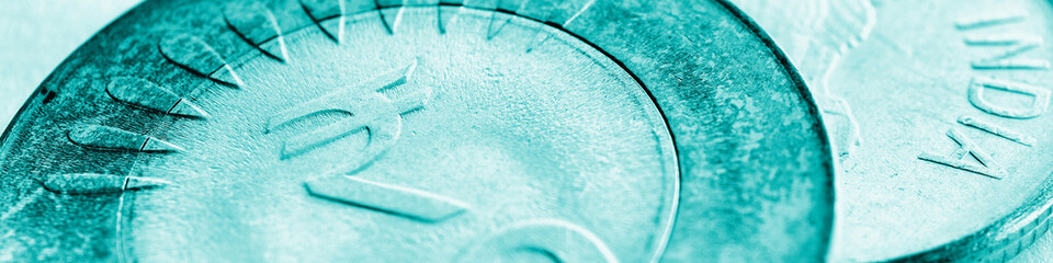 Two Indian coins. 10 rupee coin with the sign of national currency closeup. Turquoise tinted...