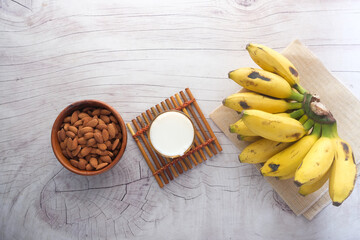 top view of banana, milk and almond nut on table 
