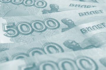 Several Russian banknotes of 5000 rubles closeup. Light blue gray tinted background or wallpaper about money and currency of Russia. Economy and banks. Macro