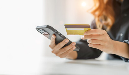 Women holding credit card and using smartphones at home.Online shopping, internet banking, store online, payment, spending money, e-commerce payment at the store, credit card, concept