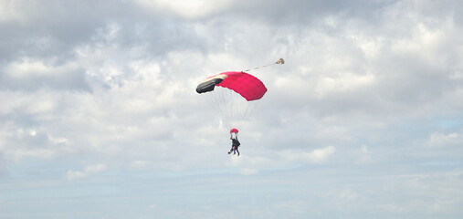Duas pessoas a saltar de paraquedas, skydive, desporto radical, com o céu enublado - desporto radical - obrazy, fototapety, plakaty