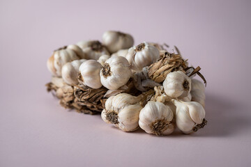 Fragrant Garlic wreath lies on light background. Agriculture and farming