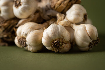 Fragrant Garlic wreath lies on olive background. Agriculture and farming