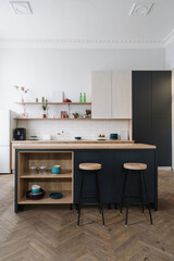 Modern kitchen with wooden cabinets and bar chairs near dining table