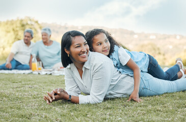 The world doesnt love you like your family loves you. Shot of a mother and daughter laying on the grass in a park.