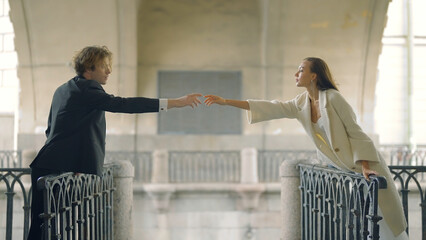Lovers hold out their hands to each other at distance. Action. Beautiful couple in love on...