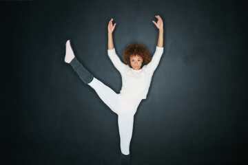 When words fail, dance triumphs. Studio shot of an attractive young woman dancing against a gray background.