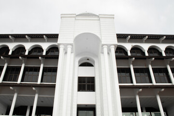 The mosque building is white with a high gate