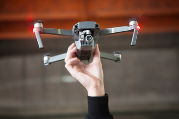 Hand holding photography and videography flying drone copter in air