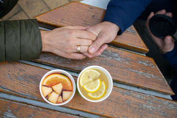 man and woman holding hands with tea