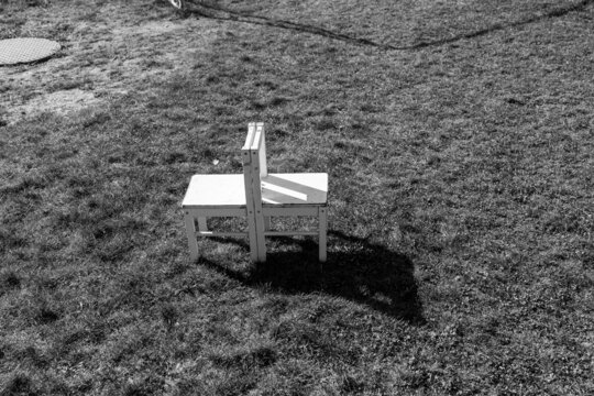 Zwei kleine weiße Stühle stehen im Gras
