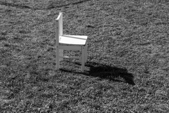 Ein leerer weißer Stuhl steht in der Wiese