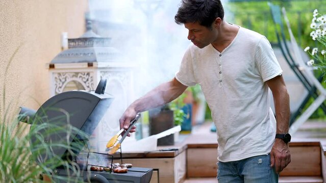 Person grilling food at backyard grill