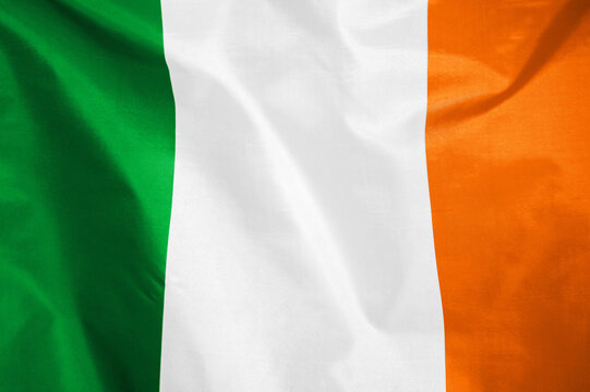 Fabric texture flag of Ireland. Flag of Ireland waving in the wind. Ireland flag is depicted on a sports cloth fabric with many folds. Sport team banner - Powered by Adobe