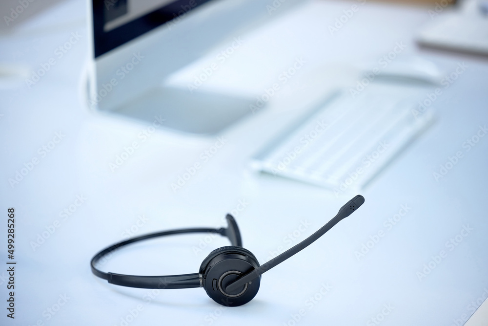 Poster dont know what to do dial our number. shot of a headset on a desk in a modern office.