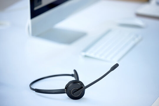 Dont Know What To Do Dial Our Number. Shot Of A Headset On A Desk In A Modern Office.