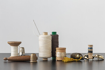 Fototapeta na wymiar Spools of thread, needle, golden buttons and thimbles