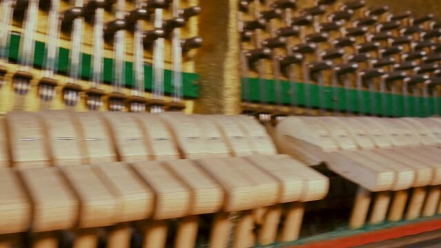Closeup dolly shot of the internal mechanism of an old vintage piano with hammers and strings. Musical instrument, classical or jazz music, art and culture.