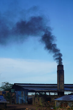 Old factory chimney of a brickyard in the Amazon region of Brazil. The circular kiln is operated with tropical wood and all materials that burn. The smoke is black and pollutes the air. Manaus, Brazil