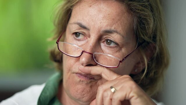 A meditative older woman portrait face in contemplation pensive senior person