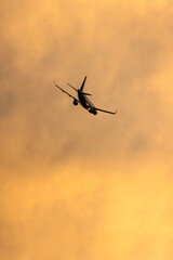 Airliner coming in for a landing with a vibrant colorful sunset sky in the background