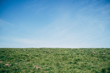 Fototapeta na wymiar Grassy dyke against blue sky