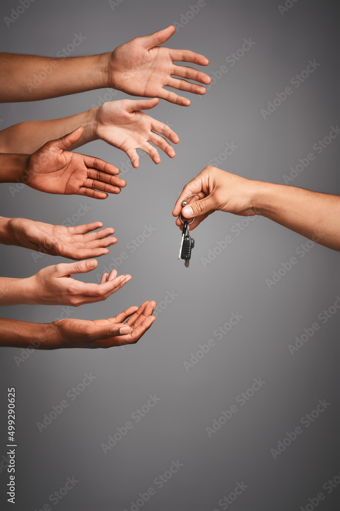 Poster vying for the drivers seat. studio shot of unidentifiable hands reaching for a set of keys against a