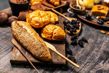 Selection of bread and loaf with cereals bread and bakery, breadsticks on wooden table in dark background with copy space