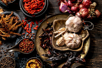 Assortment spices and seasonings with herbs on kitchen dark wooden table such as star anise, black pepper, cinnamon, bay leaf, for medicinal and herbal use in healing and cooking concept