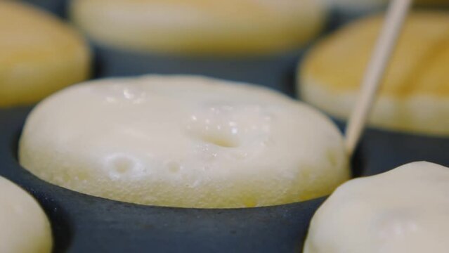 Cooking Sweet Dutch Pancakes Poffertjes. Close up in slow motion