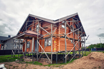 Wooden house architecture. House built from logs. Wooden log house. Log cabin, permanent wood foundations under construction. House on pile foundation.