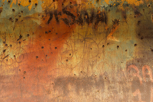 Rusty metal plate with bullet holes