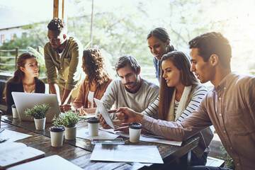 Breaking away from the office to do business. Shot of a team of colleagues using a digital tablet...