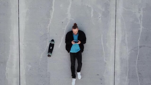 Man or teen laying in the middle of a road making chat conversation with empty words