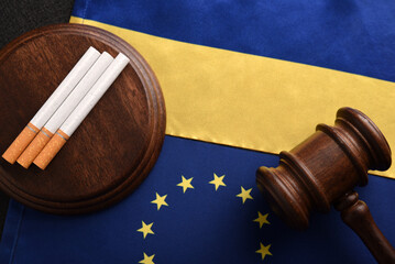 Flag of Ukraine with flag of European Union, cigarettes and Judge gavel. Smuggling between Ukraine and EU. Illegal transport of tobacco products.