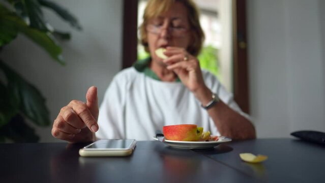 An older woman using cellphone device at home a senior person uses smartphone