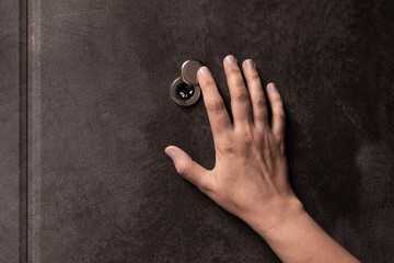 Door peephole and hand. peephole close-up. female hand opens the door peephole cover. Close-up....