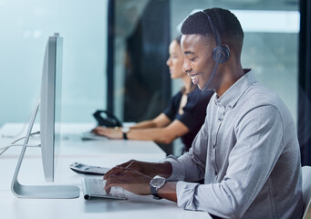 Im always happy to help. Shot of a young call centre agent typing in an office. - Powered by Adobe