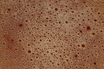 Saw-gold foam. Detail of bubbles illuminated by light. Beer foam texture. Roughened surface.