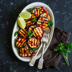 Teriyaki sauce spicy grilled aubergine - a delicious snack, tapas on a dark background