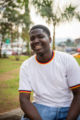 Portrait of a smiling young African boy, happy young adult outside