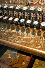 Old Fashioned cash register. Close detail on the keys and drawer of an elaborately decorated...