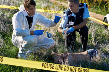 Examining the evidence. Shot of two investigators examining evidence at a crime scene.