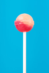 Multi-colored candies on a stick, blue background.Many colorful lollipops (Chyupa-Chyups) on a blue background