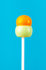 Multi-colored candies on a stick, blue background.Many colorful lollipops (Chyupa-Chyups) on a blue background