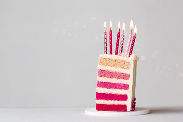 Slice of pink ombre birthday cake with candles