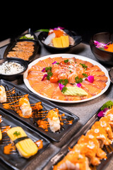 Sashimi sushi set with soy on black background.Assorted sushi set served on dark stone slate background. Top view