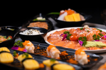 Sashimi sushi set with soy on black background.Assorted sushi set served on dark stone slate background. Top view