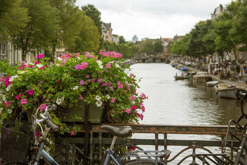 Amsterdam traditional postcard view: canal, bike and flowers